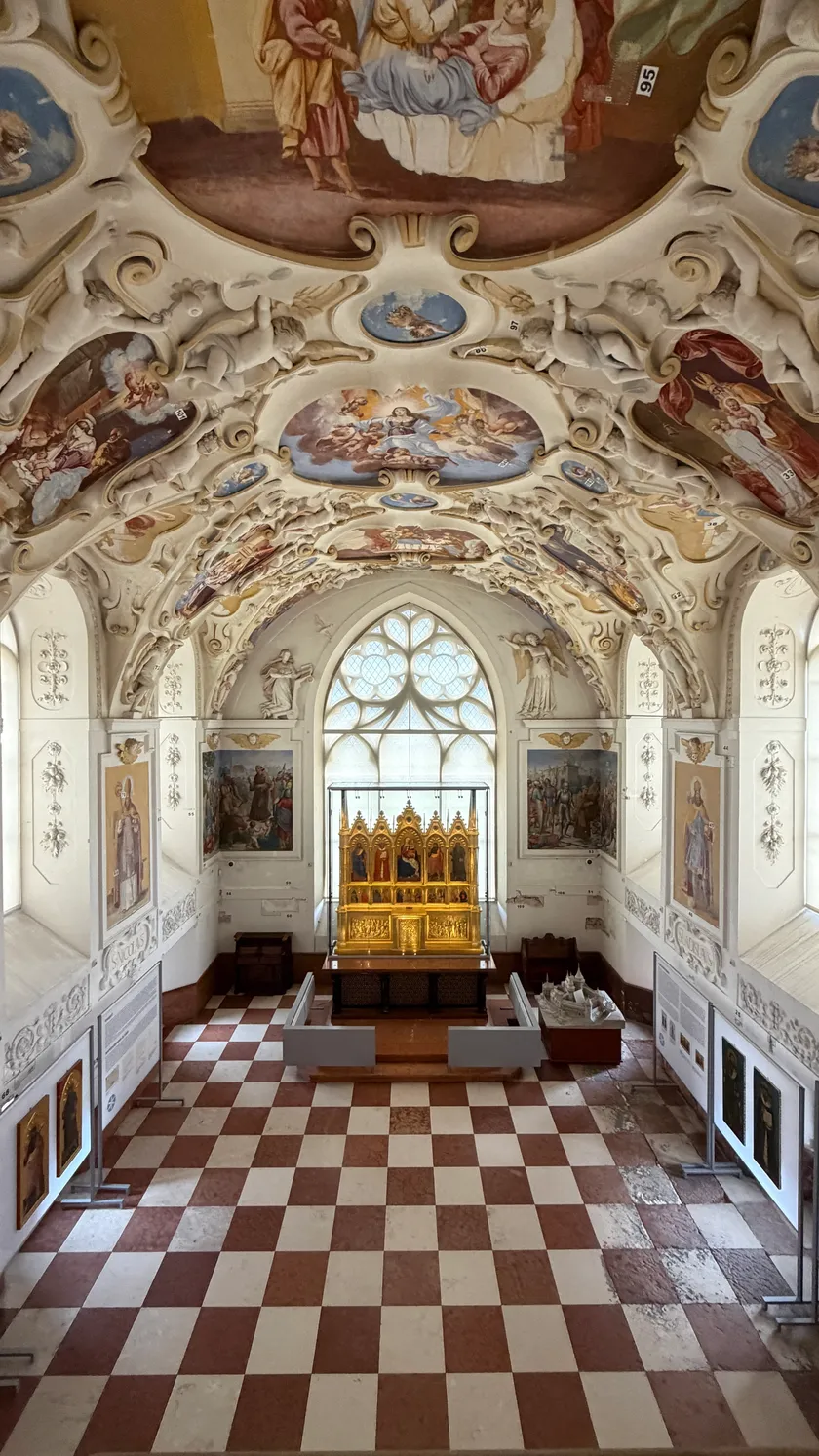 Castle chapel with an ornate painted ceiling and golden altar