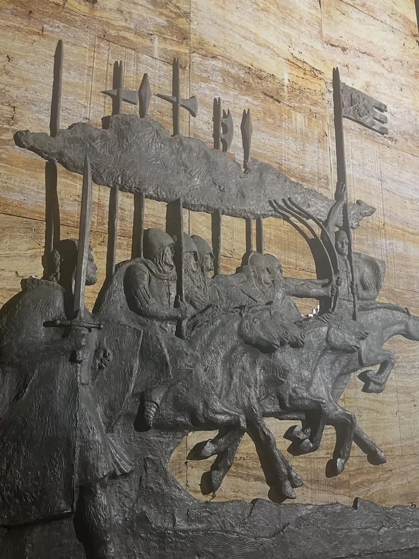 Bronze relief of mounted warriors in battle