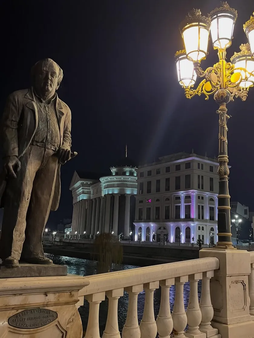 Statue on the Stone Bridge with an ornate street lamp and historic buildings
